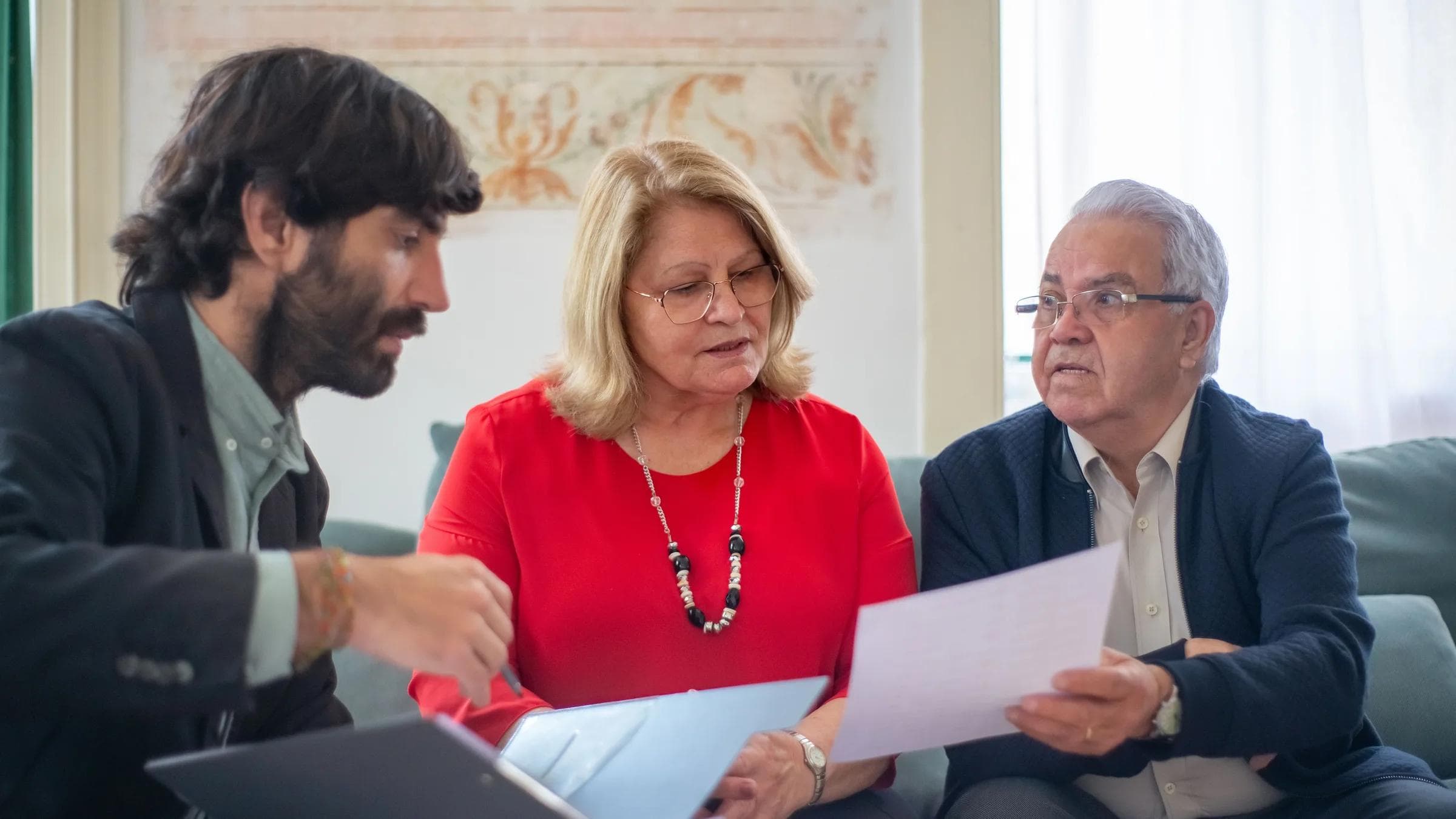 A professional advisor reviews documents with an older couple.