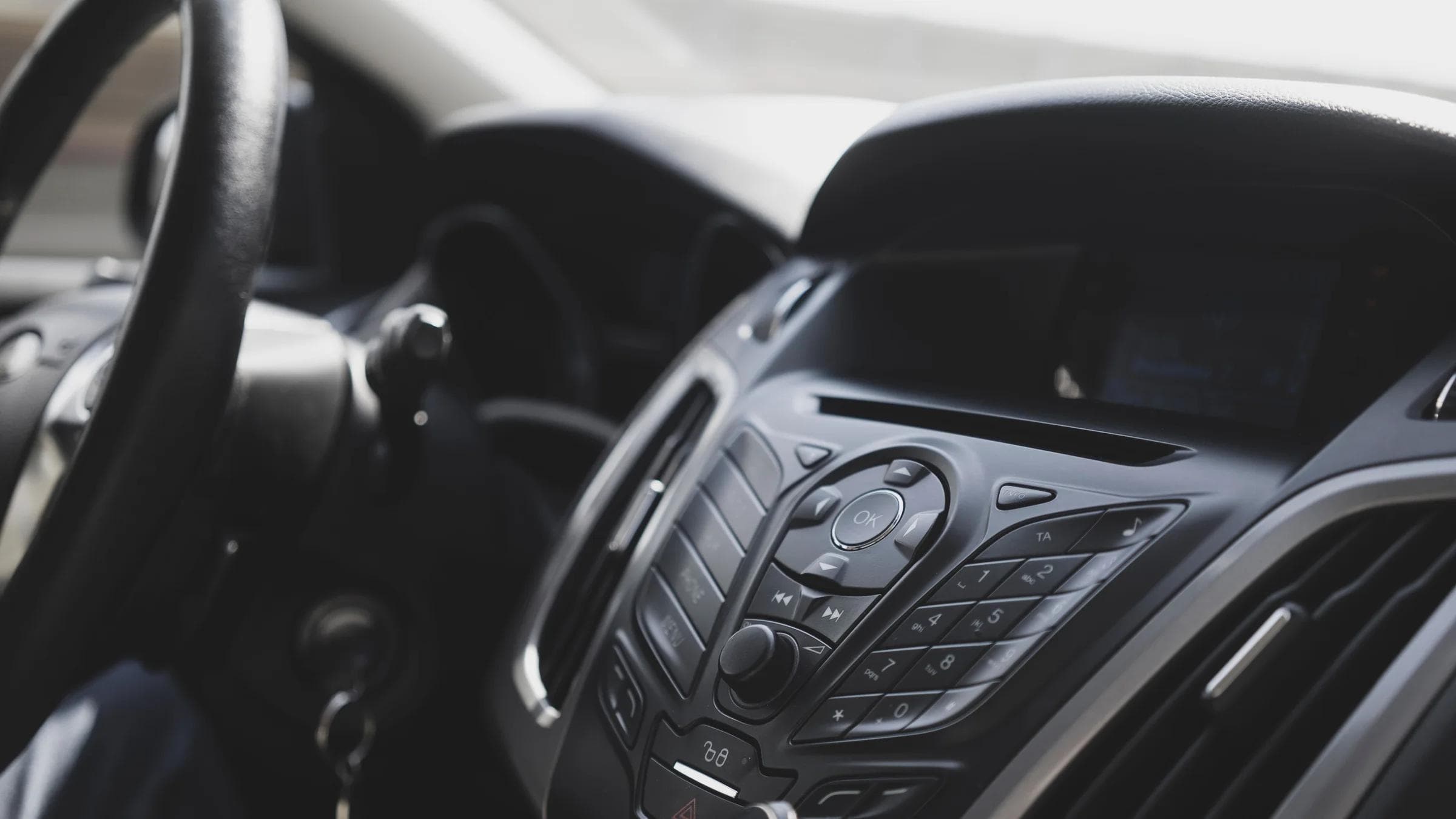 Close-up view of a modern car interior focusing on the dashboard and steering wheel.