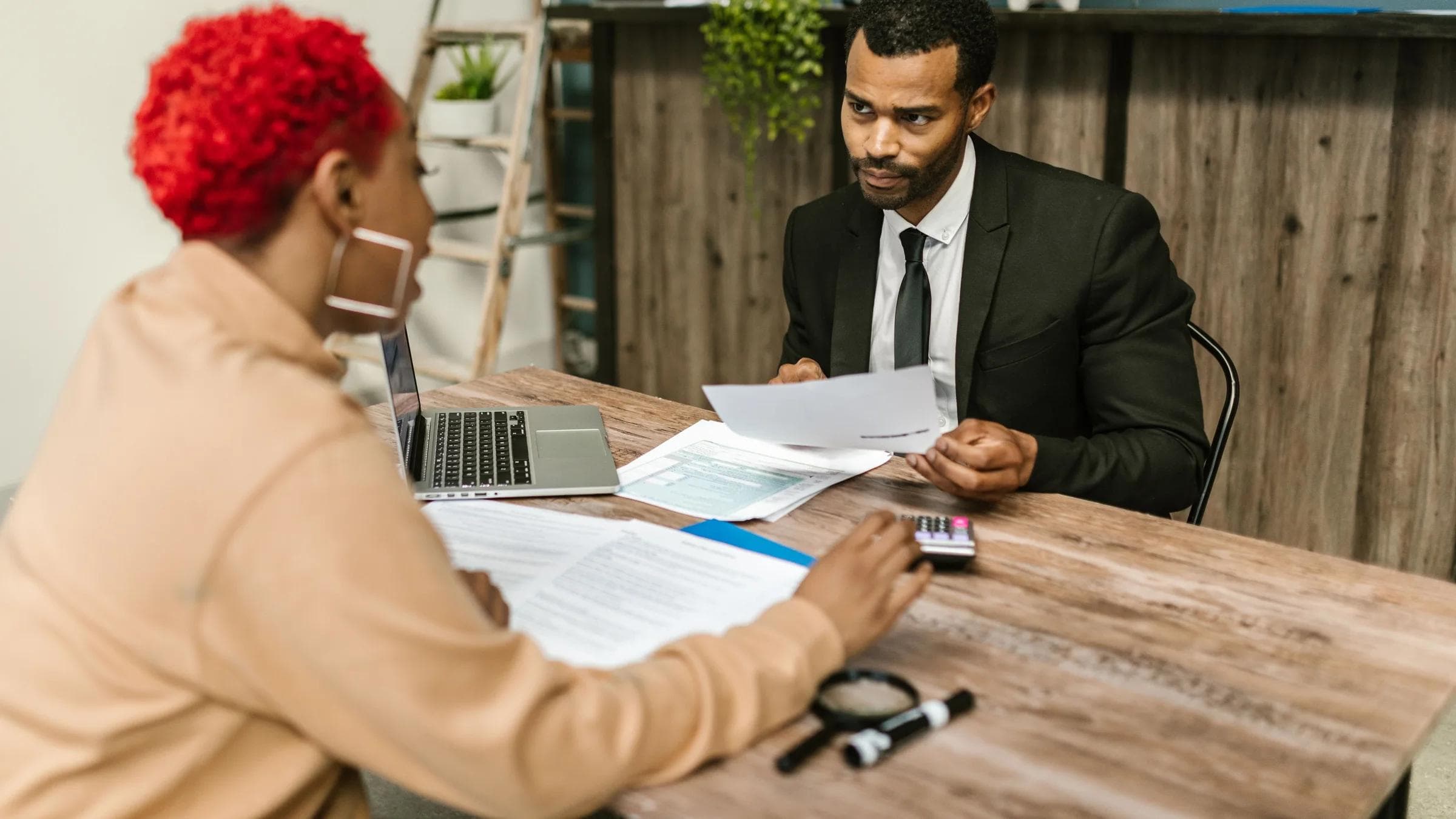 A discussion between two professionals focusing on financial documents in a modern office setting.