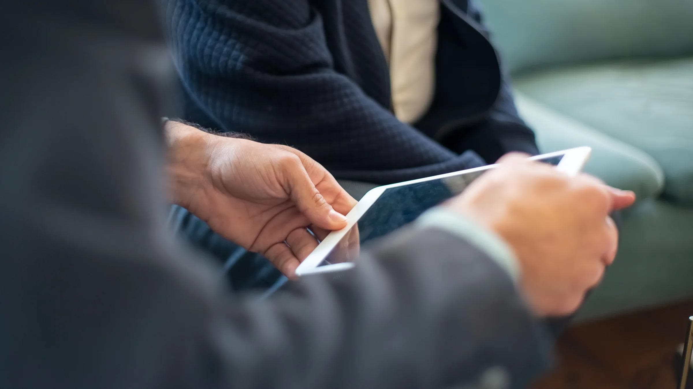Two business people using a tablet during an indoor meeting. Perfect for tech and collaboration themes.