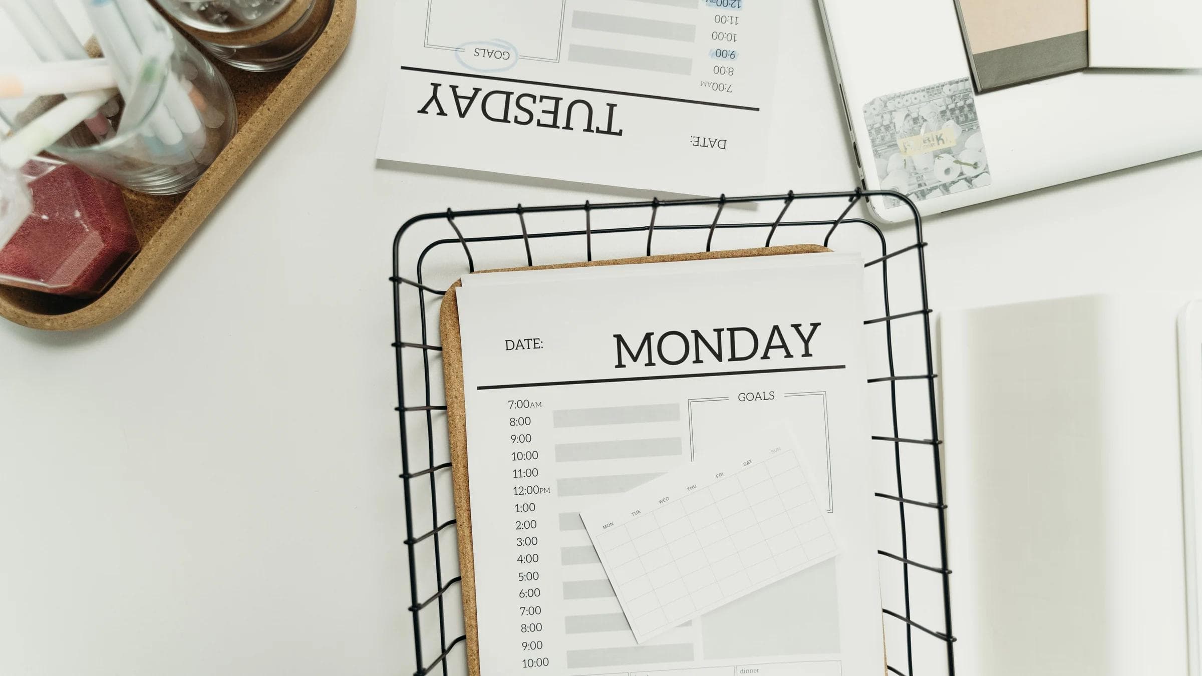 Top view of a modern, minimalist weekly planner setup showing Monday and Tuesday pages.
