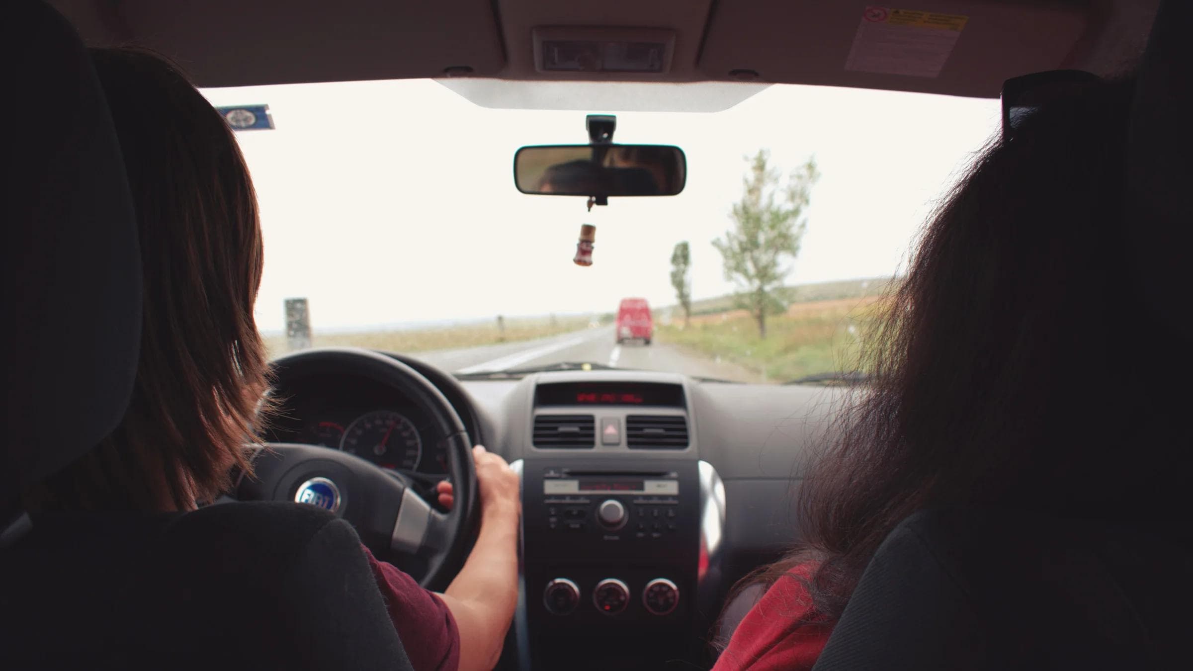 Two adults traveling by car on a scenic road near Iași, Romania.