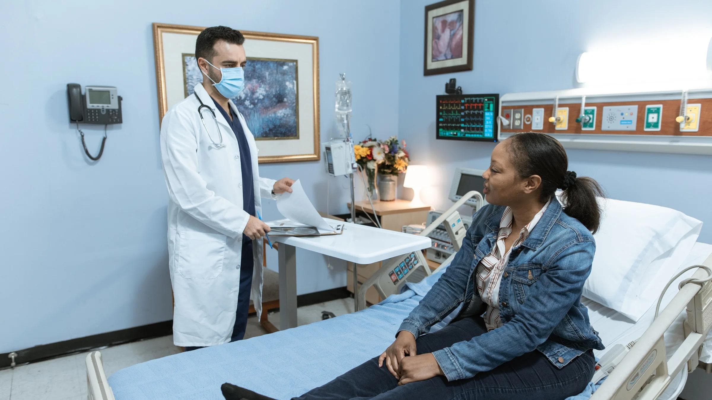 A medical professional conducts a check-up with a patient in a hospital setting.