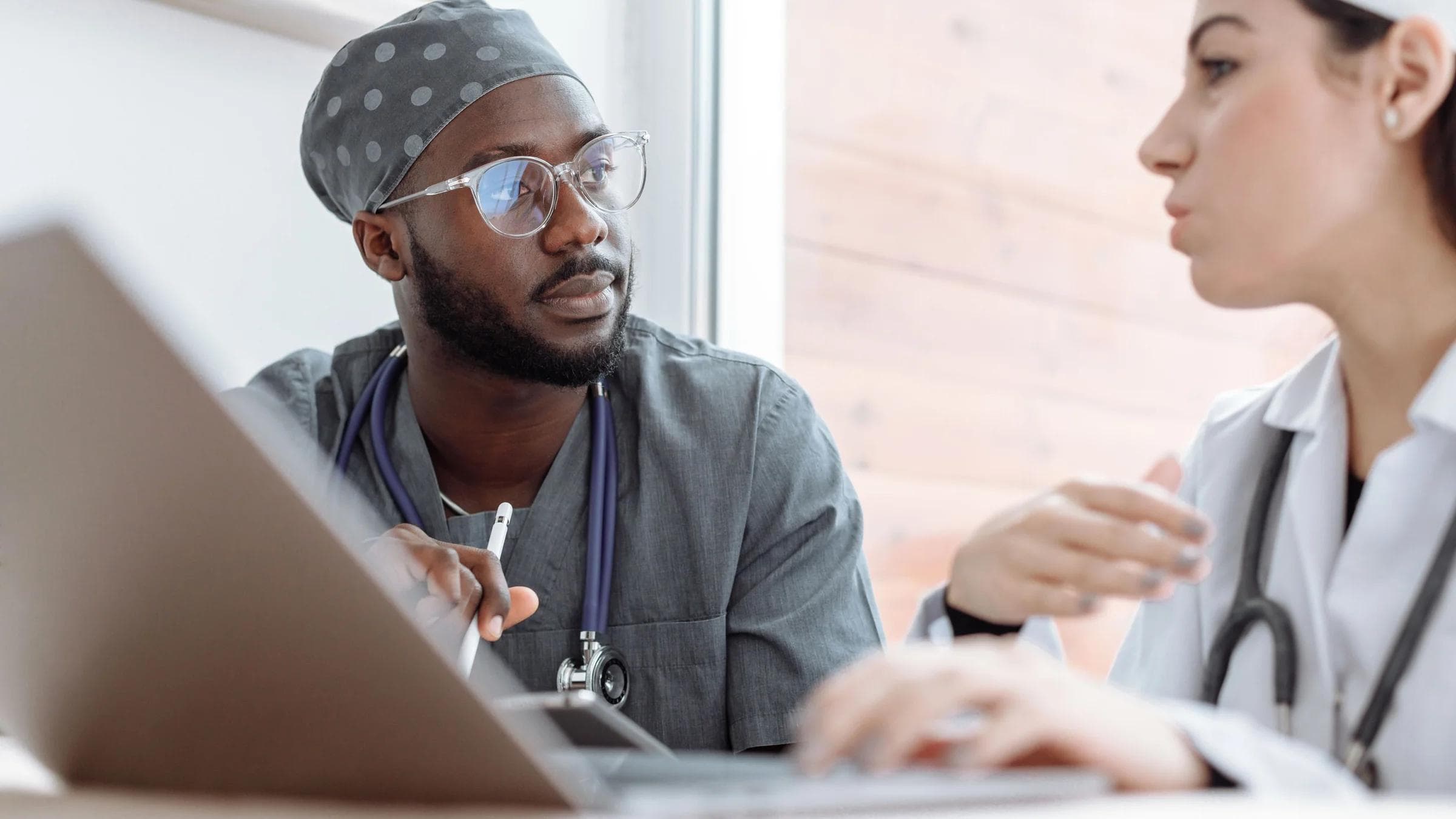 Two healthcare workers in conversation, focusing on collaboration and patient care.
