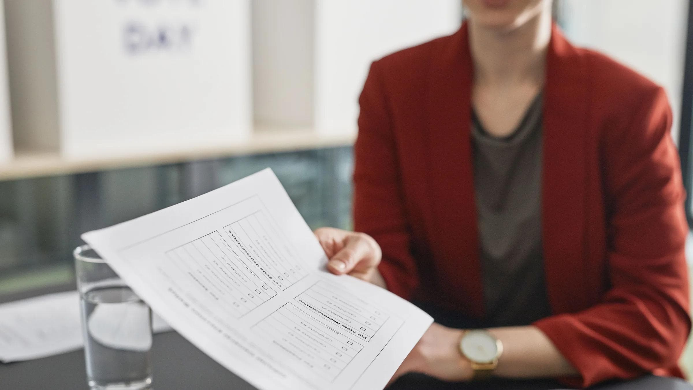 Close-up of a person handing over a business document during a meeting.
