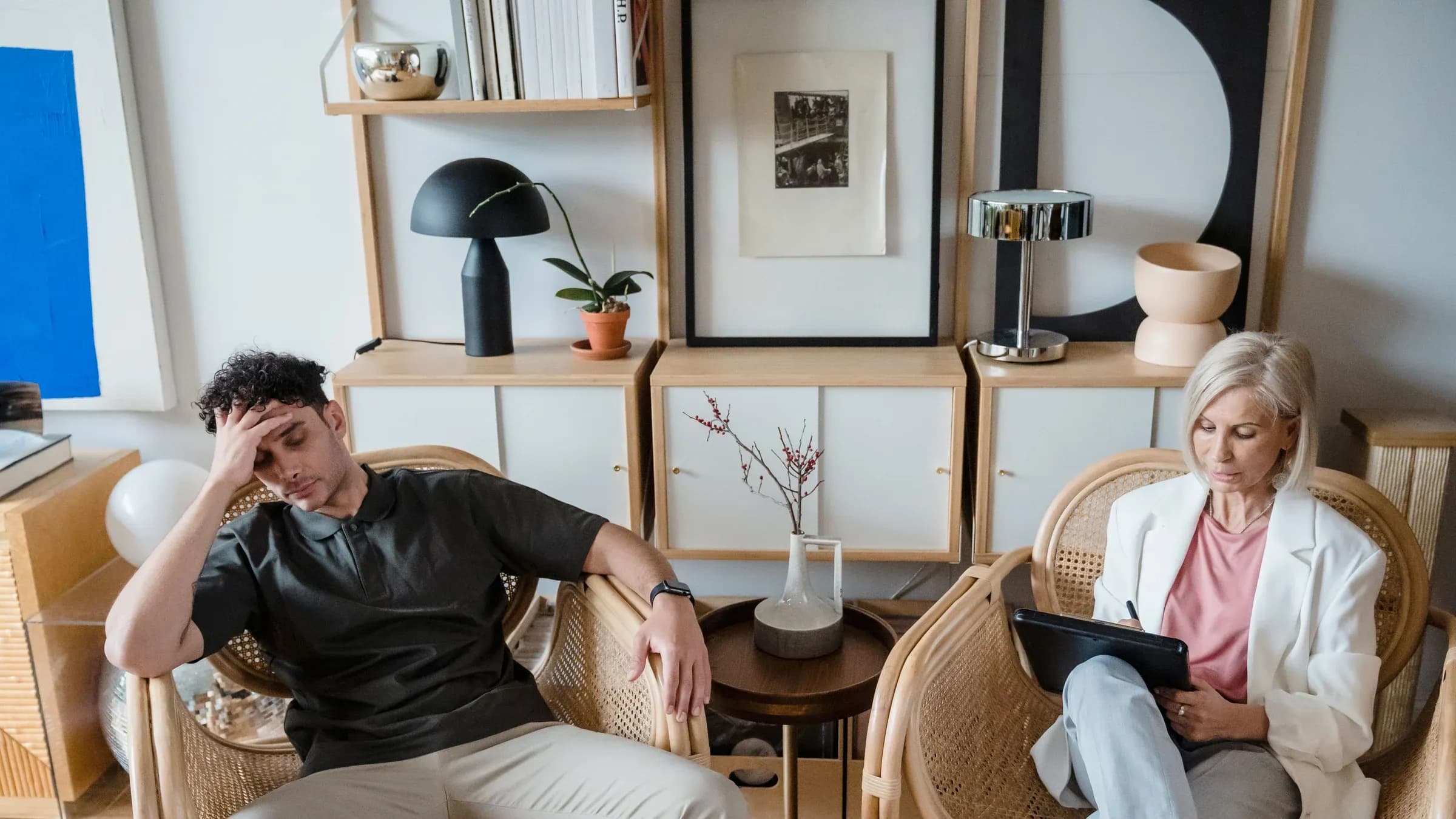 A stressed man and woman therapist in a modern consultation room.