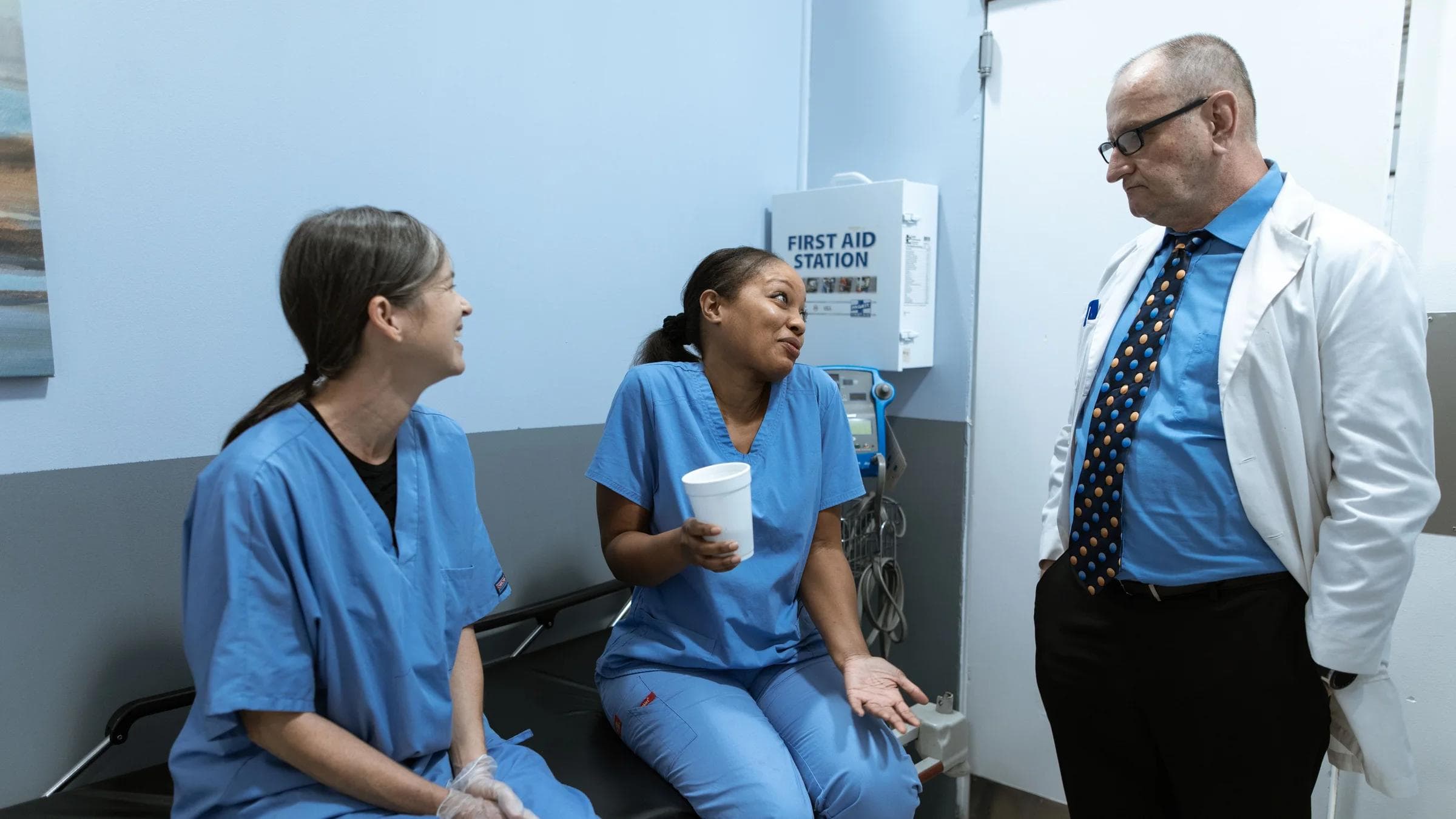 Doctors and nurses engaging in casual conversation in a medical setting.