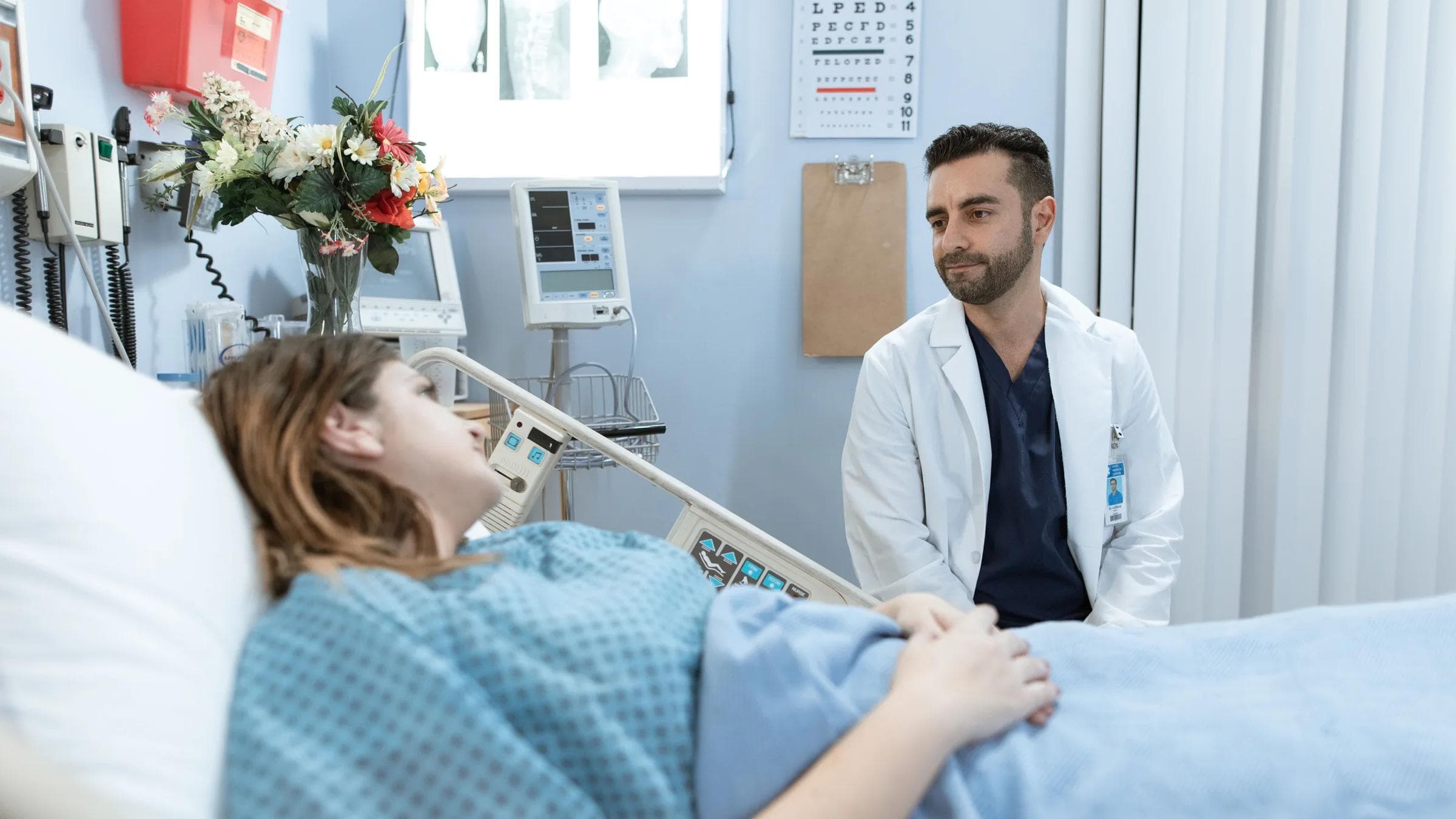 A doctor comforts a patient in a hospital room, emphasizing professional care.